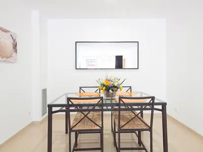 a dining room table with chairs and a vase of flowers at Charmsuites Paralel in Barcelona