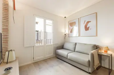 a living room with a couch and a window at Bcn Town Apartments Born in Barcelona