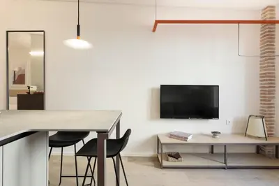 a living room with a table and a tv on a wall at Bcn Town Apartments Born in Barcelona