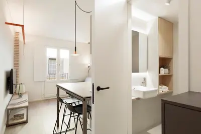 a white kitchen with a table and a sink at Bcn Town Apartments Born in Barcelona