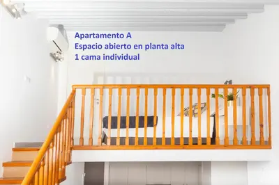 a wooden staircase in a room with a chair at Sitges Rustic Apartments in Sitges
