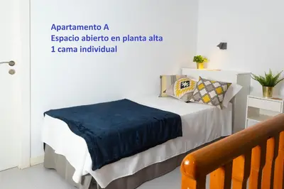 a bedroom with a bed with a blue blanket on it at Sitges Rustic Apartments in Sitges
