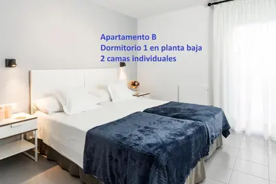 a bedroom with a bed with a blue blanket on it at Sitges Rustic Apartments in Sitges
