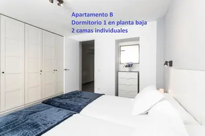 a bedroom with a white bed and white cabinets at Sitges Rustic Apartments in Sitges