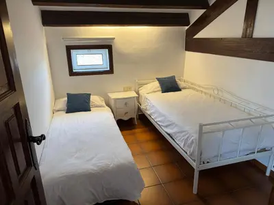 two beds in a small room with a window at Apartament Cal Negre in Vilassar de Mar