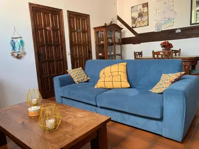 a blue couch in a living room with a table at Apartament Cal Negre in Vilassar de Mar