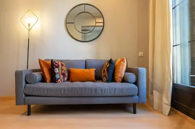 a blue couch with pillows in a living room with a mirror at Bonavista Apartments - Eixample in Barcelona