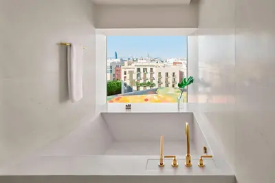 a white bathroom with a sink and a window at The Barcelona EDITION in Barcelona