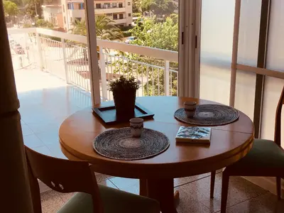 a wooden table with two cups on top of a balcony at Solimar in Castelldefels