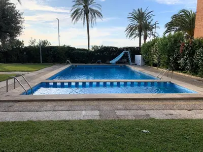 a swimming pool with a slide in a yard at Solimar in Castelldefels