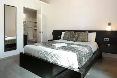 a bedroom with a black and white bed and a bathroom at BruStar Gotic-Centric in Barcelona