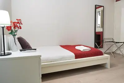 a bedroom with a bed with a red blanket and a mirror at BruStar Gotic-Centric in Barcelona