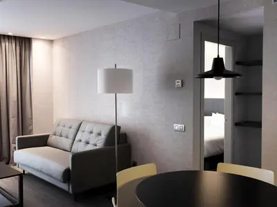 a living room with a couch and a table at Hg City Suites Barcelona Apartments in Barcelona