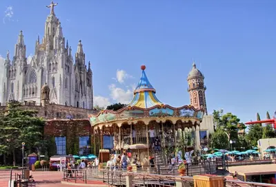 a carousel in front of a building with a cathedral at 8 min walk to the beach & 10 min walk to Convention Centre ! in Barcelona