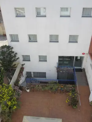 a building with blue benches in front of it at Hotel Blauet by Bossh! Hotels in El Prat de Llobregat