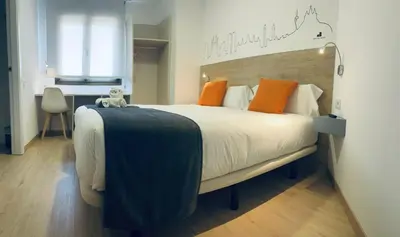 a bedroom with a bed and a desk and a chair at Hostal Sans in Barcelona