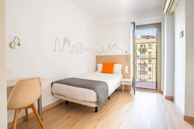 a room with a bed and a balcony with a view at Hostal Sans in Barcelona