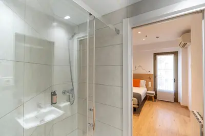 a bedroom with a bed and a desk with a computer at Hostal Sans in Barcelona