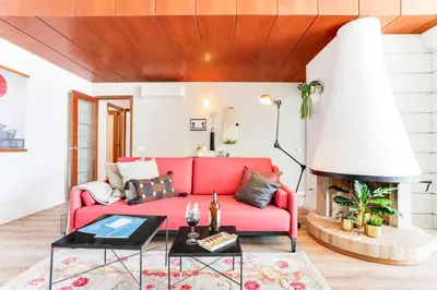 a living room with a red couch and a fireplace at Sweett - Eixample Borrell in Barcelona