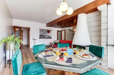 a dining room with a table and green chairs at Sweett - Eixample Borrell in Barcelona