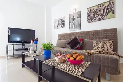 a living room with a couch and a table with a bowl of bread at Charmsuites Nou Rambla in Barcelona