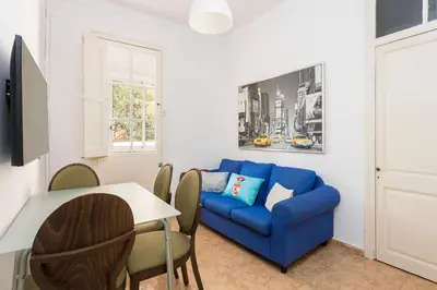 a living room with a blue couch and a table at Apartament Clot 1 in Barcelona