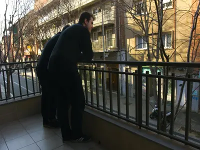 two men standing on a balcony looking at the street at Hostal Badaloní in Badalona