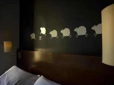 a bedroom with a headboard with sheep stenciled on it at Hostal Badaloní in Badalona