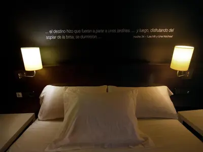 a bedroom with a bed with two lights on it at Hostal Badaloní in Badalona