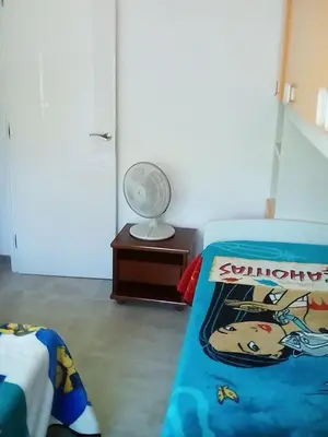 a bedroom with a bed and a fan and a table at Piso luminoso en Barcelona in Barcelona