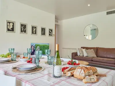 a table with bread and a bottle of wine at BarcelonaForRent Vila Olimpica Pool Suites in Barcelona