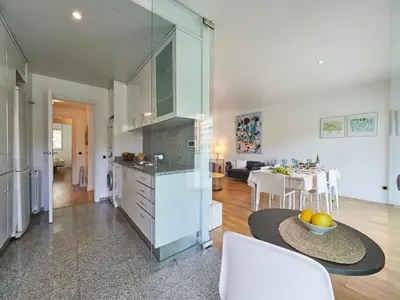 a kitchen and living room with a table and a dining room at BarcelonaForRent Vila Olimpica Pool Suites in Barcelona