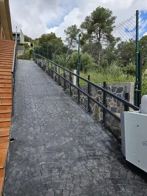 a cobblestone walkway with a fence on the side at Casa Lourdes in Canyelles