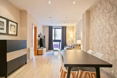 a dining room and living room with a table and chairs at Alcam Alio 2 in Barcelona