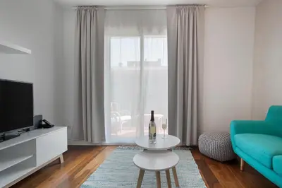 a living room with a blue couch and a table at Tendency Rambla del Poblenou in Barcelona