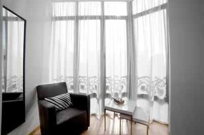 a black chair sitting in front of a window at Serennia Apartamentos Ramblas - Plaça Catalunya in Barcelona