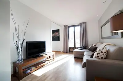 a living room with a couch and a flat screen tv at Serennia Apartamentos Ramblas - Plaça Catalunya in Barcelona