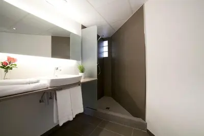 a bathroom with a sink and a shower at Serennia Apartamentos Ramblas - Plaça Catalunya in Barcelona