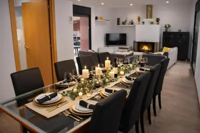 a dining room table with candles and black chairs at Villa Sitges La Calma 10 minutes drive Sitges 2 minutes walk Garraf Park AC in Sant Pere de Ribes