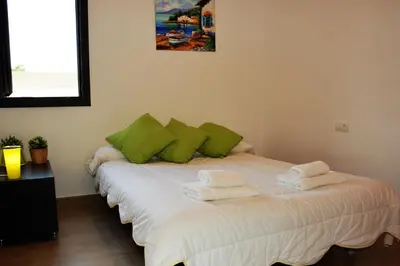 a room with a bed with green pillows on it at Villa Sitges La Calma 10 minutes drive Sitges 2 minutes walk Garraf Park AC in Sant Pere de Ribes