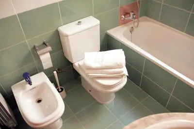 a bathroom with a toilet and a sink and a bath tub at Alguera Apartments Napols in Barcelona
