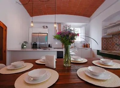 a dining room table with plates and a vase of flowers at The Painter's Home in Vilassar de Mar