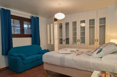 a bedroom with a bed and a blue chair at ARTS HOUSE - Cabrils, Maresme, Barcelona in Cabrils