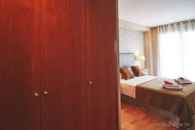 a bedroom with a bed and a large wooden cabinet at Alcam Badalona Playa Norte in Badalona
