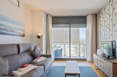 a living room with a couch and a tv at Alcam Badalona Playa Norte in Badalona