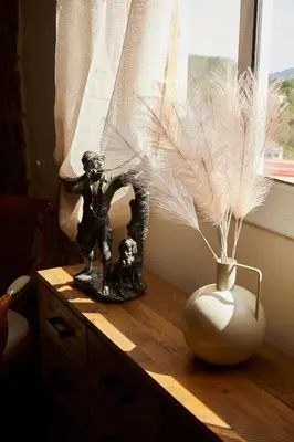 a table with a statue and a vase with feathers at Amazing Vila close to Sitges, jacuzzi, swimming pool & exellent views in Olivella