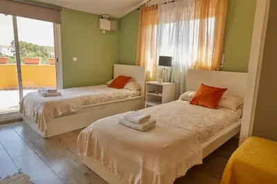 two beds in a room with green walls and a window at Amazing Vila close to Sitges, jacuzzi, swimming pool & exellent views in Olivella