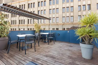 a patio with tables and chairs and a building at Enjoybcn Dali Apartments in Barcelona
