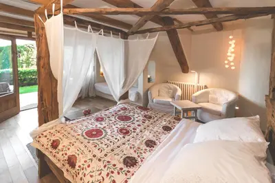 a bedroom with a large bed and two chairs at Can Caponet in Lliçà d'Amunt