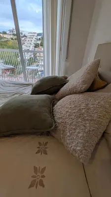a bed with pillows on it in a room with a window at Tropical Apartaments Euroviajeros in Pineda de Mar